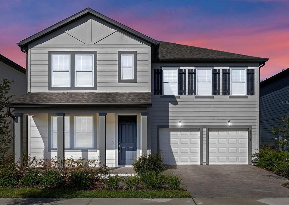 Two-story gray home with white garage doors at dusk, Winter Garden, Florida